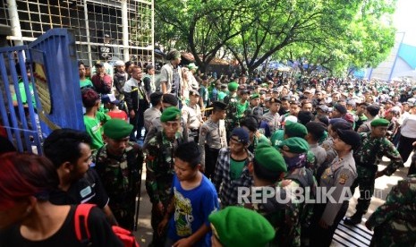  Petugas gabungan TNI dan polisi menjaga para bonek keluar dari GOR Pajajaran, Jalan Pajajaran, Kota Bandung, Ahad (8/1).