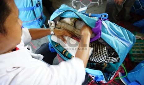   Petugas Garuda Indonesia menyita air zamzam dari barang bawaan jamaah haji Indonesia di fasilitas baggage handling Garuda Indonesia, Jeddah, Selasa (29/10).    (Republika/Yogi Ardhi)