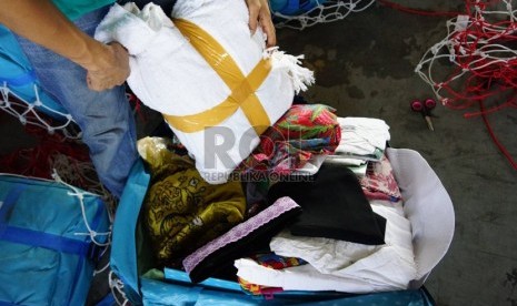   Petugas Garuda Indonesia menyita air zamzam dari barang bawaan jamaah haji Indonesia di fasilitas baggage handling Garuda Indonesia, Jeddah, Selasa (29/10).    (Republika/Yogi Ardhi)