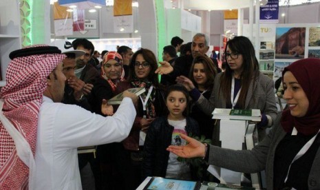 Petugas gerai Saudi di Pameran Buku Internasional Tunisia membagikan mushaf Alquran secara cuma-cuma. 