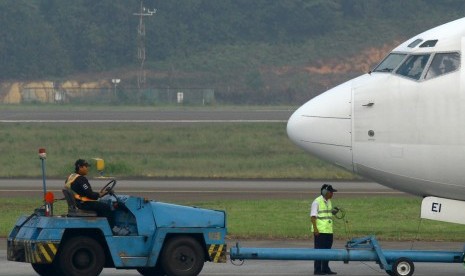 Petugas ground handling menyiapkan salah satu maskapai yang hendak terbang.