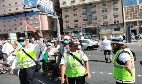 Petugas haji Indonesia membantu penyeberangan jamaah di Sektor 1, Daerah Mahbas Jin, Makkah, Jumat (1/7/2022). Sembilan Bus Antar Jamaah Haji Medan ke Madinah