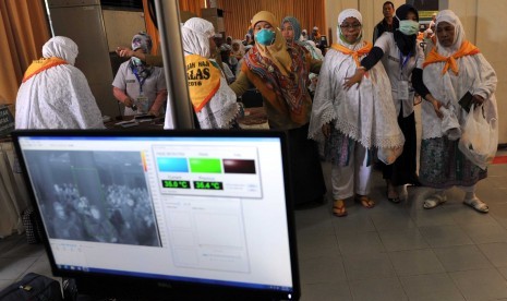 Petugas haji melakukan scan tubuh pada seorang jamaah haji.