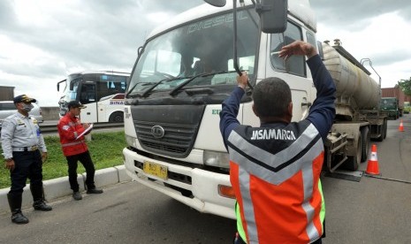 Petugas Jasa Marga dan Dinas Perhubungan mengarahkan truk yang membawa muatan untuk ditimbang saat Operasi tertib kendaraan bermuatan lebih yang berlangsung 31 Januari-6 Februari 2017, di Jalan Tol Jakarta-Cikampek KM 41, Cikarang, Jawa Barat, Senin (6/2).