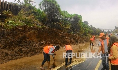  Petugas jasa marga sedang membersihkan tanah bekas longsoran di tol Cipularang KM 118, di wilayah Desa Sukatani Kecamatan Padalarang, Kabupaten Bandung Barat. Ahad (10/4). 