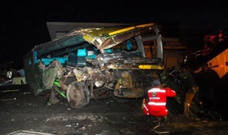 Petugas Jasa Raharja dibantu kepolisian berusaha mengevakuasi bangkai bus Karunia Bakti yang terperosok usai menyebabkan kecelakaan beruntun di kawasan Cisarua, Bogor, Jawa Barat, Sabtu (11/2). 