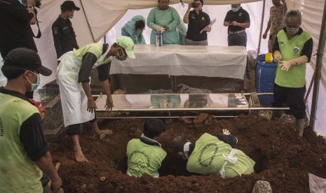 Petugas Jatanras Polda Metro Jaya dibantu Petugas Sudin Pertamanan dan Pemakaman Jakarta Pusat membongkar makam korban persekusi toko vape, Abi Qowi Suparto ketika dilakukan autopsi di Pemakaman Karet Tengsin, Jakarta, Selasa (12/9).