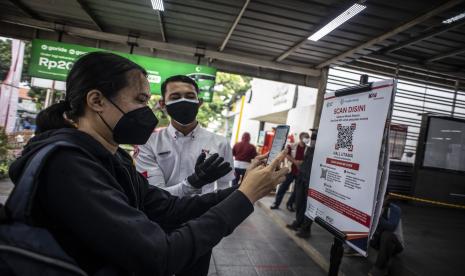 Petugas KAI Commuter mempersilahkan calon penumpang memindai kode batang (QR Code) melalui aplikasi PeduliLindungi sebelum menaiki KRL di Stasiun Manggarai, Jakarta, Selasa (7/9/2021). PT Kereta Api Indonesia (Persero) atau KAI mendukung integrasi transportasi di Jabodetabek. 