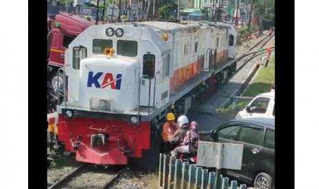 Petugas KAI menyelamatkan pengendara sepeda motor