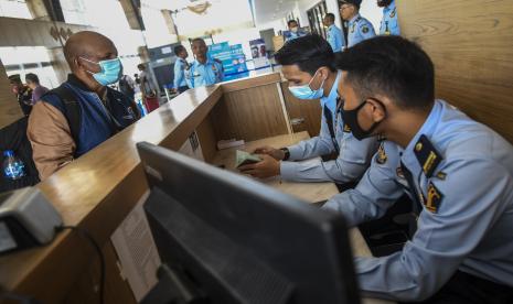 Petugas Kantor Imigrasi Kelas I TPI Atambua memeriksa paspor seorang pelintas batas di Pos Lintas Batas Negara Terpadu (PLBNT) Mota Ain, Desa Silawan, Kabupaten Belu NTT, Senin (23/5/2022). Sejak Pemerintah mulai melonggarkan pemberlakuan pembatasan kegiatan masyarakat (PPKM) menjadi level 2, Warga Negara Indonesia (WNI) yang menuju Timor Leste meningkat dari yang biasanya hanya 2-5 orang pelintas per hari saat PPKM masih berlangsung, kini menjadi 60-100 orang per hari, sedangkan Warga Negara Asing dari Timor Leste yang akan menuju Indonesia saat PPKM masih berlaku hanya sekitar 1-2 orang per hari, kini meningkat menjadi 30-50 orang pelintas per hari.