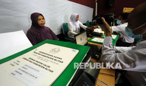 Petugas Kantor Imigrasi Kelas II Non TPI Blitar merekam data Jamaah Calon Haji (JCH) tahun 2021 di Kantor Kementrian Agama Blitar, Jawa Timur, Rabu (7/4/2021). Perekaman data untuk permohonan paspor tersebut tetap dilaksanakan oleh Kemenag yang bekerjasama dengan Imigrasi, meski pemerintah Indonesia belum mendapat informasi terkait kepastian penyelenggaraan haji tahun 2021. 