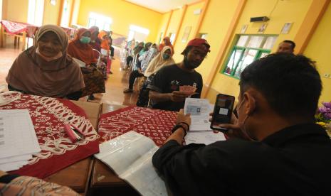 Petugas Kantor Pos Indonesia memfoto warga penerima manfaat saat penyaluran bantuan langsung tunai bahan bakar minyak (BLT BBM) di Mudal, Boyolali, Jawa Tengah, Kamis (8/9/2022). Sebanyak 63.225 keluarga penerima manfaat (KPM) menerima BLT BBM dan program sembako di Boyolali dengan jumlah Rp500 ribu per KPM. 