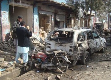 Petugas keamanan Afghanistan (kiri) menginvestigasi lokasi serangan bom bunuh diri di Lashkar Gah, Provinsi Helmand, Afghanistan, Kamis (26/1).