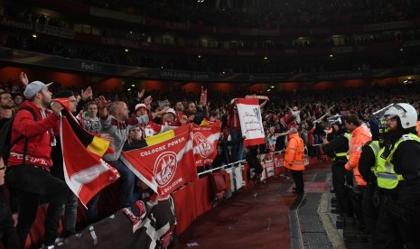 Petugas keamanan berjaga di depan pendukung FC Cologne ketika klub asal Jerman itu bertandang ke markas Arsenal, Stadion Emirate, pada laga perdana fase grup Liga Europa, Kamis (14/9) waktu setempat atau Jumat (15/9) WIB.