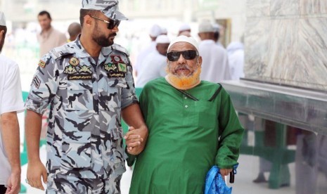 500 Personel Keamanan Layani Jamaah di Masjidil Haram selama Ramadhan. Foto: Petugas keamanan Masjidil Haram membimbing jamaah haji yang buta saat tersesat.