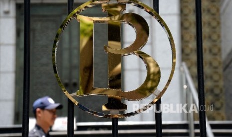 Petugas keamanan melintas didekat logo Bank Indonesia (BI), Jakarta, Ahad (1/10). (Republika/Prayogi)