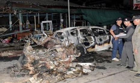 Petugas keamanan memeriksa bangkai mobil di lokasi ledakan di Kota Sungai Kolok, Provinsi Narathiwat, Thailand Selatan, Jumat (16/9).