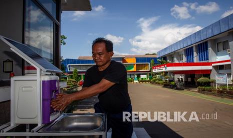 Petugas keamanan mencuci tangan di wastafel kreasi sekolah yang menggunakan tenaga surya di SMKN 26 Rawamangun, Jakarta Timur, Sabtu (30/5/2020). Sejumlah persiapan dilakukan SMKN 26 Rawamangun dalam rangka pelayanan Penerimaan Peserta Didik Baru (PPDB) 2020 dengan standar protokol pencegahan penyebaran COVID-19.