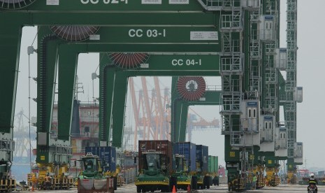 Petugas keamanan mengawasi proses bongkar muat kontainer di Terminal Teluk Lamong, Surabaya, Jawa Timur, Minggu (19/3).