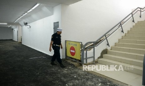 Petugas keamanan mengecek kondisi terkini terowongan penyebrangan orang di Stasiun Manggarai, Jakarta, Jumat (25/11). 