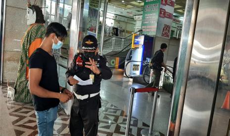 Petugas keamanan mengecek surat vaksinasi yang dibawa pengunjung ketika hendak masuk pintu masuk timur Blok A Pasar Tanah Abang, Jakarta Pusat, Selasa (27/7). 