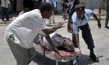 Petugas keamanan mengevakuasi korban ledakan yang terjadi di Teater Nasional, Mogadishu, Somalia,Rabu (4/4),   (Foto: Mohamed Sheikh Nor/AP)