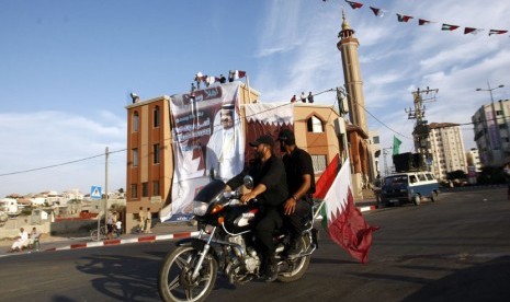  Petugas keamanan Palestina mengendarai sepeda motor di depan sebuah spanduk Emir Qatar Sheikh Hamad bin Khalifa al-Thani, di sebuah masjid di Kota Gaza,Palestina (Ilustrasi)