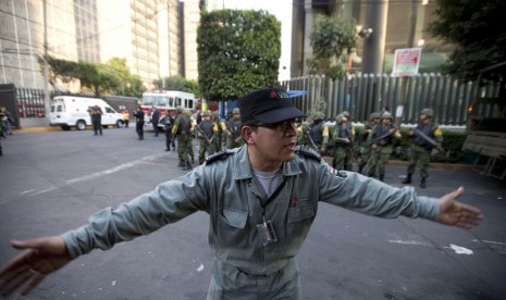  Petugas keamanan Pemex,perusahaan minyak milik negara, menghalau para jurnalis agar menjauh dari lokasi ledakan di Gedung Pemex di Mexico City, Kamis (31/1).  (AP/Eduardo Verdugo)