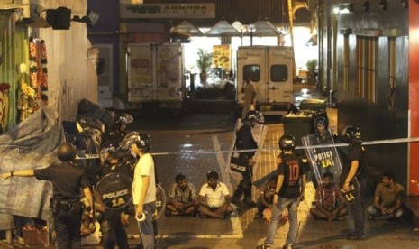 Petugas keamanan Singapura mengamankan sejumlah orang terkait kerusuhan di kawasan Little India pada Ahad (8/12/2013)