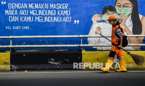 Petugas kebersihan melintas di depan mural tentang pandemi COVID-19 di Kawasan Tebet, Jakarta, Selasa (15/9/2021). Gubernur DKI Jakarta Anies Baswedan memperpanjang masa pemberlakuan pembatasan kegiatan masyarakat (PPKM) berbasis mikro selama dua pekan atau hingga 28 Juni 2021, hal tersebut dilakukan karena penyebaran COVID-19 di Jakarta dalam kondisi yang memerlukan perhatian ekstra. 