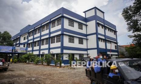 Petugas kebersihan melintas di depan sekolah yang akan dijadikan rumah isolasi terkonsentrasi (RIT) di SMPN 30 Kota Tangerang, Banten, Senin (21/6/2021). Pemerintah Kota Tangerang akan menjadikan SMPN 30 Kota Tangerang sebagai rumah isolasi terkonsentrasi (RIT) khusus pasien COVID-19 lantaran kasur khusus pasien COVID-19 di RIT yang ada hampir terisi sepenuhnya.