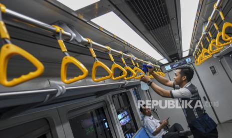 Petugas kebersihan membersihkan pegangan tangan (hand grip) gerbong Light Rail Transit (LRT). ilustrasi (Antara/Nova Wahyudi)