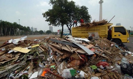 Petugas kebersihan membersihkan sampah yang berada di silang Monas, Jakarta Pusat, Senin (15/9). Lebaran Betawi yang diadakan sejak hari Sabtu hingga Ahad (14/9) ini menimbulkan sampah yang menumpuk, sehingga merusak keindahan monas.