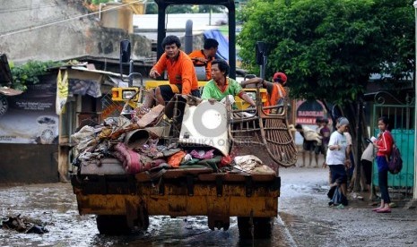   Petugas kebersihan mengangkut sampah-sampah yang menumpuk di kampung Melayu Besar, Jakarta Selatan, Selasa (14/1). (Republika/Prayogi)