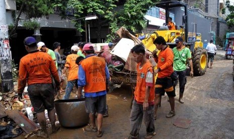   Petugas kebersihan mengangkut sampah-sampah yang menumpuk di kampung Melayu Besar, Jakarta Selatan, Selasa (14/1). (Republika/Prayogi)