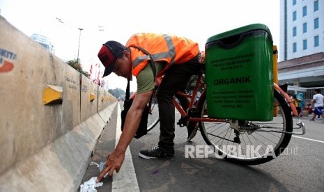 Petugas kebersihan mengendarai sepeda saat berpatroli memungut sampah (ilustrasi)