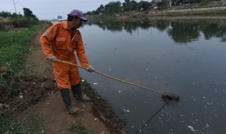 Petugas kebersihan mengeruk lumpur di Kanal Banjir Timur (KBT), Pulogebang, Jakarta, Senin (28/9).