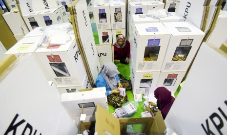 Petugas Kelompok Panitia Pemungutan Suara (KPPS) memeriksa kelengkapan logistik Pemilu sebelum didistribusikan ke kelurahan di gudang logistik KPU Jakarta Pusat, GOR Tanah Abang, Jakarta, Senin (15/4/2019).