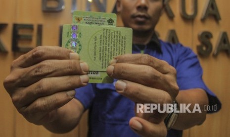 Petugas Kementerian Agama (Kemenag) menunjukan Kartu Nikah di kantor Kemenag, Jakarta, Senin (12/11/2018). 