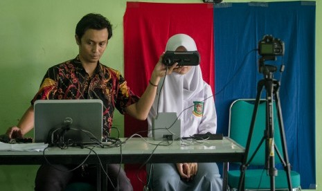 Petugas Kependudukan dan Catatan Sipil (Dispendukcapil) melakukan perekaman data e-KTP kepada pelajar usia 15-16 tahun di SMA 5 Solo, Jawa Tengah, Rabu (14/11/2018). 