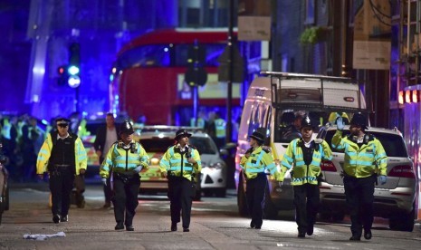 Petugas kepolisian berada di Borough High Street menangani insiden di London Bridge, London, Ahad (4/6) pagi WIB. Saksi mata menyebut satu kendaraan menabrak pedestrian dan mencederai sejumlah orang.