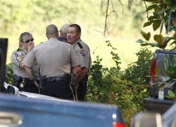 Petugas kepolisian berada di sebuah rumah di Hardin, Texas, Selasa (7/6), usai menerima kabar bahwa sejumlah mayat mutilasi dikuburkan di wilayah tersebut.