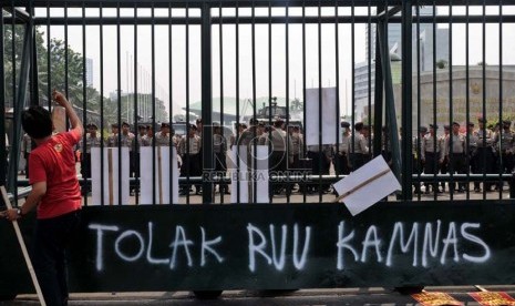  Petugas kepolisian berjaga mengamankan aksi unjukrasa menolak RUU Keamanan Nasional (Kamnas) di depan Kompleks Parlemen, Senayan, Jakarta, Selasa (23/10).  (Tahta Aidilla/Republika)