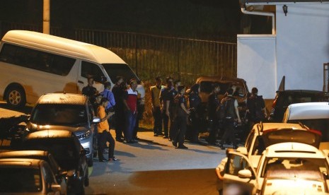 Petugas kepolisian berkumpul di luar kediaman mantan PM Malaysia Najib Razak, Kamis (17/5). Polisi menggeledah rumah Najib selama enam jam mencari bukti pencucian uang.