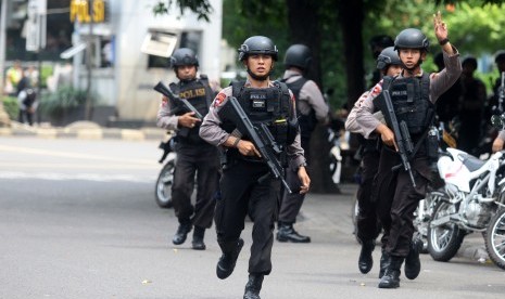 Petugas kepolisian berlari ke arah gedung Sarinah untuk melakukan pengejaran terhadap pelaku penyerangan yang dilakukan sejumlah teroris ke beberapa gedung dan pos polisi di Jakarta, Kamis (14/1). 