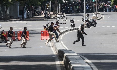 Sejumlah polisi berlari menuju ke arah gedung Sarinah untuk melakukan pengejaran terhadap pelaku  peledakan bom yang dilakukan sejumlah teroris, Kamis (14/1). 