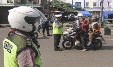 Petugas Kepolisian bersama Dishub memberikan sosialisasi kepada pengendara jelang penerapan PSBB Kota Depok di Jalan Arif Rahman, Depok, Jawa Barat, Ahad (12/4/2020). Menteri Kesehatan menyetujui menerapkan Pembatasan Sosial Berskala Besar (PSBB) di wilayah Kota Depok yang akan mulai diterapkan pada Rabu (15/4) dalam rangka percepatan penanganan COVID-19.