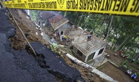 Petugas kepolisian bersama Tagana dan masyarakat membersihkan puing rumah yang tertimpa longsoran tanah di Kluwih, Pendoworejo, Kulonprogo, DI Yogyakarta, Rabu (16/12). (Antara/Andreas Fitri Atmoko)