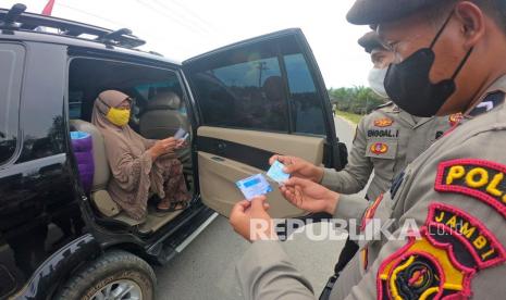 Petugas kepolisian bersama tim gabungan memeriksa syarat-syarat kelengkapan perjalanan penumpang yang akan menuju Desa Talang Bukit di Pos Penyekatan Bahar Utara, Muarojambi, Jambi, Kamis (12/8/2021). Penyekatan diberlakukan di 24 titik ruas jalan masuk Kota Jambi selama PPKM level 4 sepanjang tanggal 23-29 Agustus 2021.