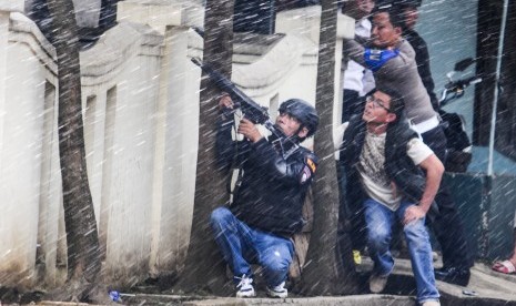 Petugas kepolisian bersenjata lengkap berusaha melumpuhkan terduga teroris di Kantor Kelurahan Arjuna, Bandung, Jawa Barat, Senin (27/2). 